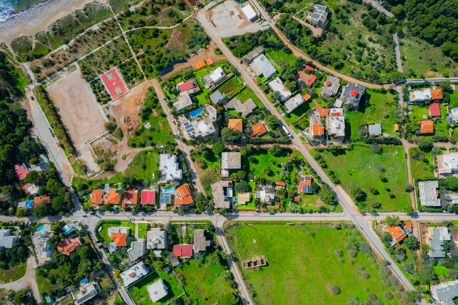 Aerial view of a residential neighbourhood with gardens and terracotta roofs
