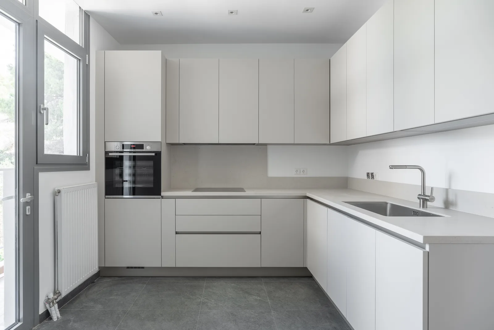White kitchen with a built in oven and an induction hob