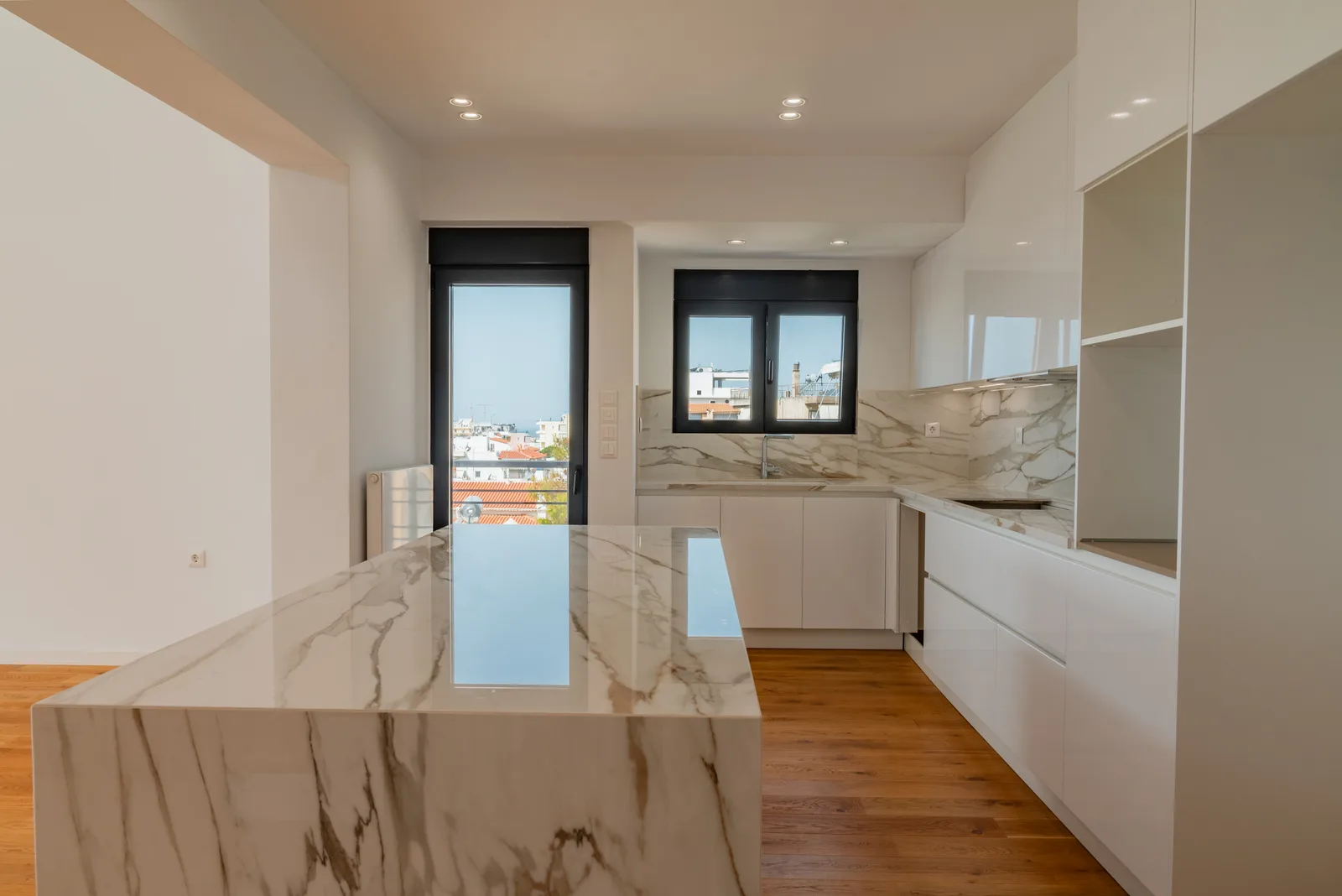 White kitchen with a marble island and a view over the city