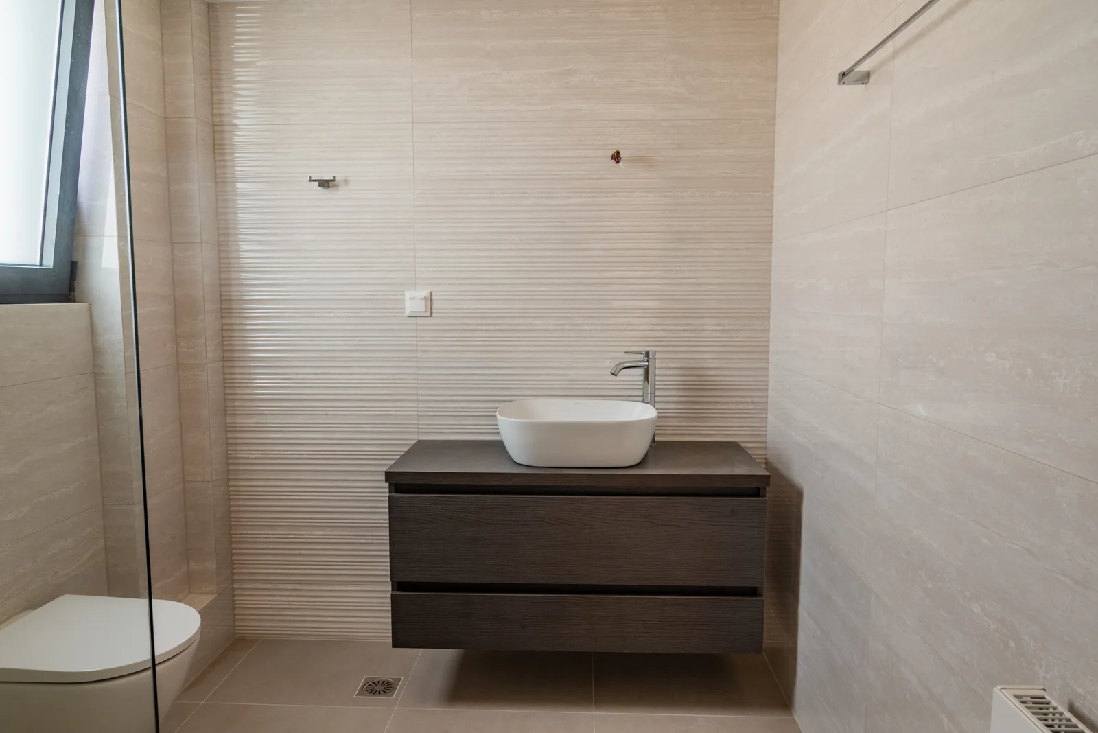 Bathroom with a vessel basin on a dark wood vanity